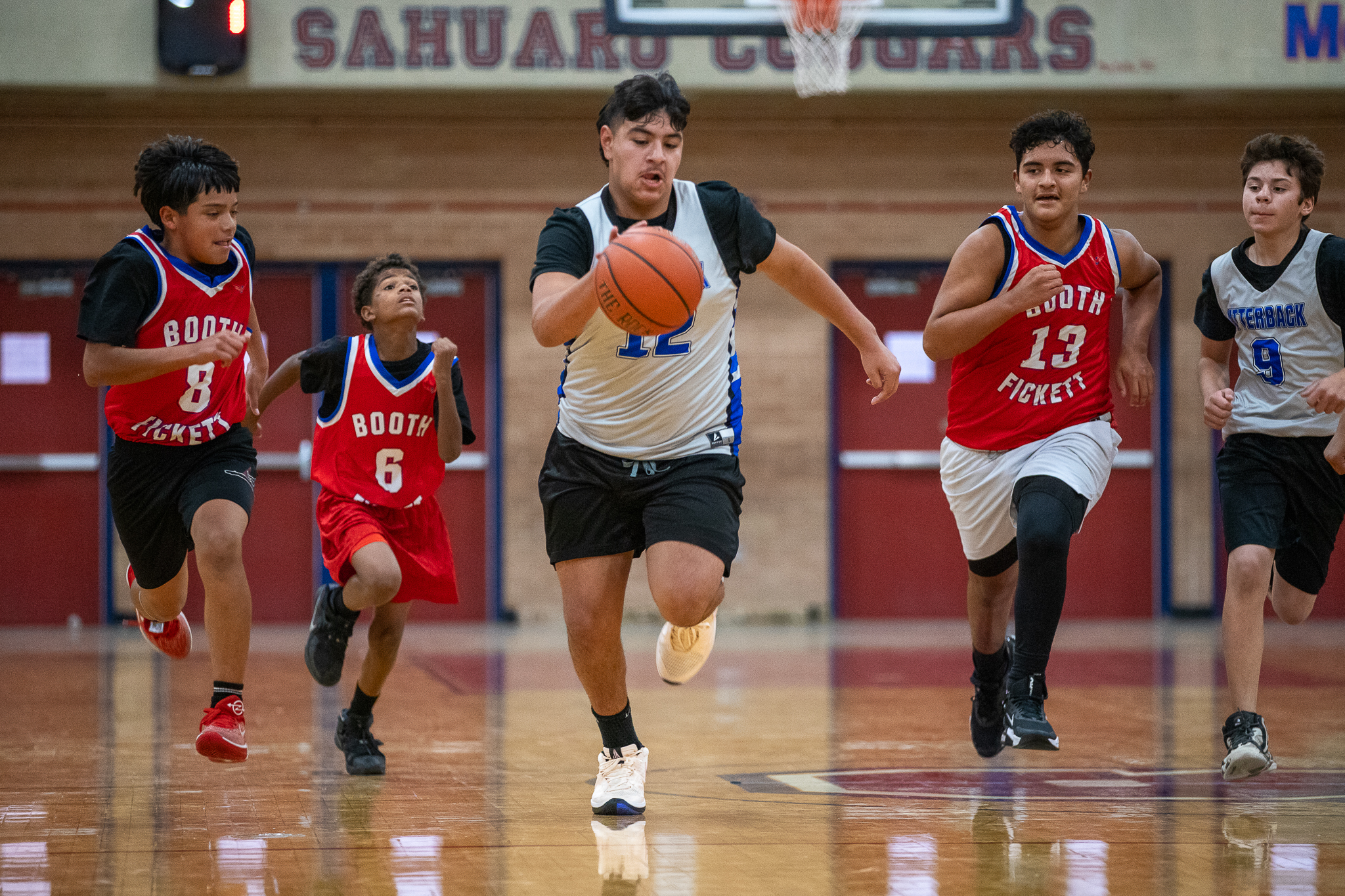 An Utterback player dribbles past his opponents on the Booth-Fickett team