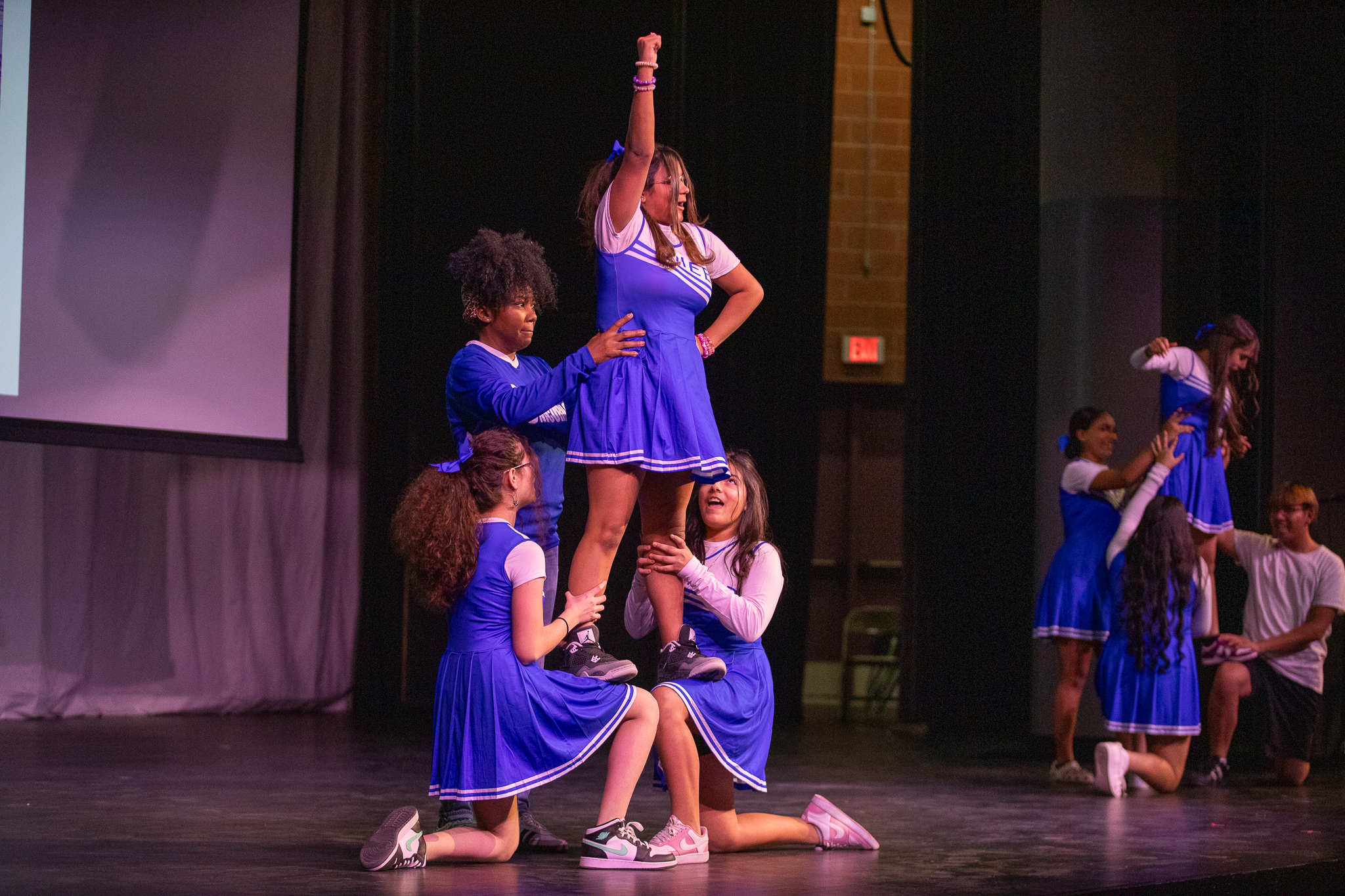 A group of girls perform cheerleading stunts