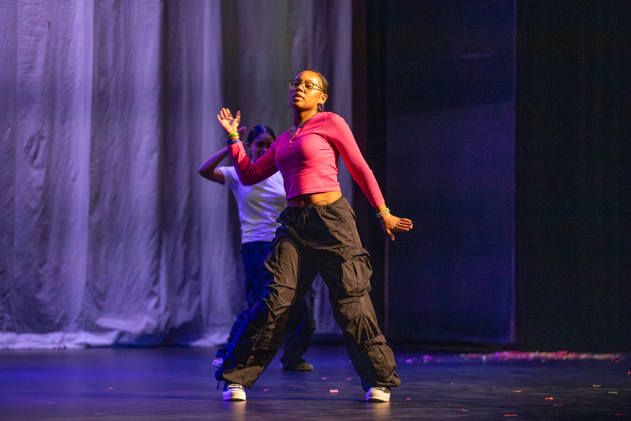 A girl in a pink top dances on stage