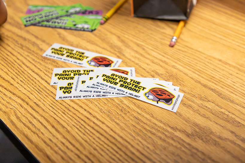 Stickers with the words Avoid the Pain! Protect Your Brain! and a cartoon of a helmet