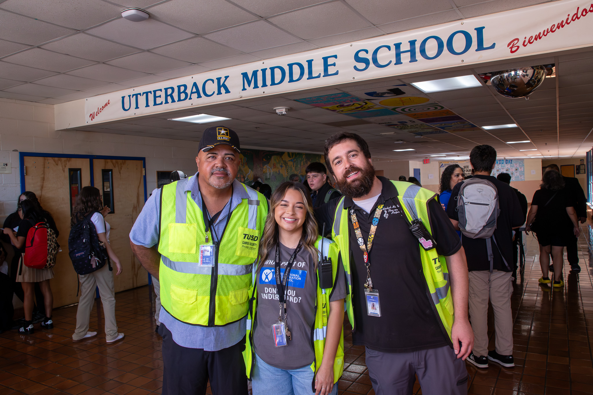 Three School Safety officers in their vests smile