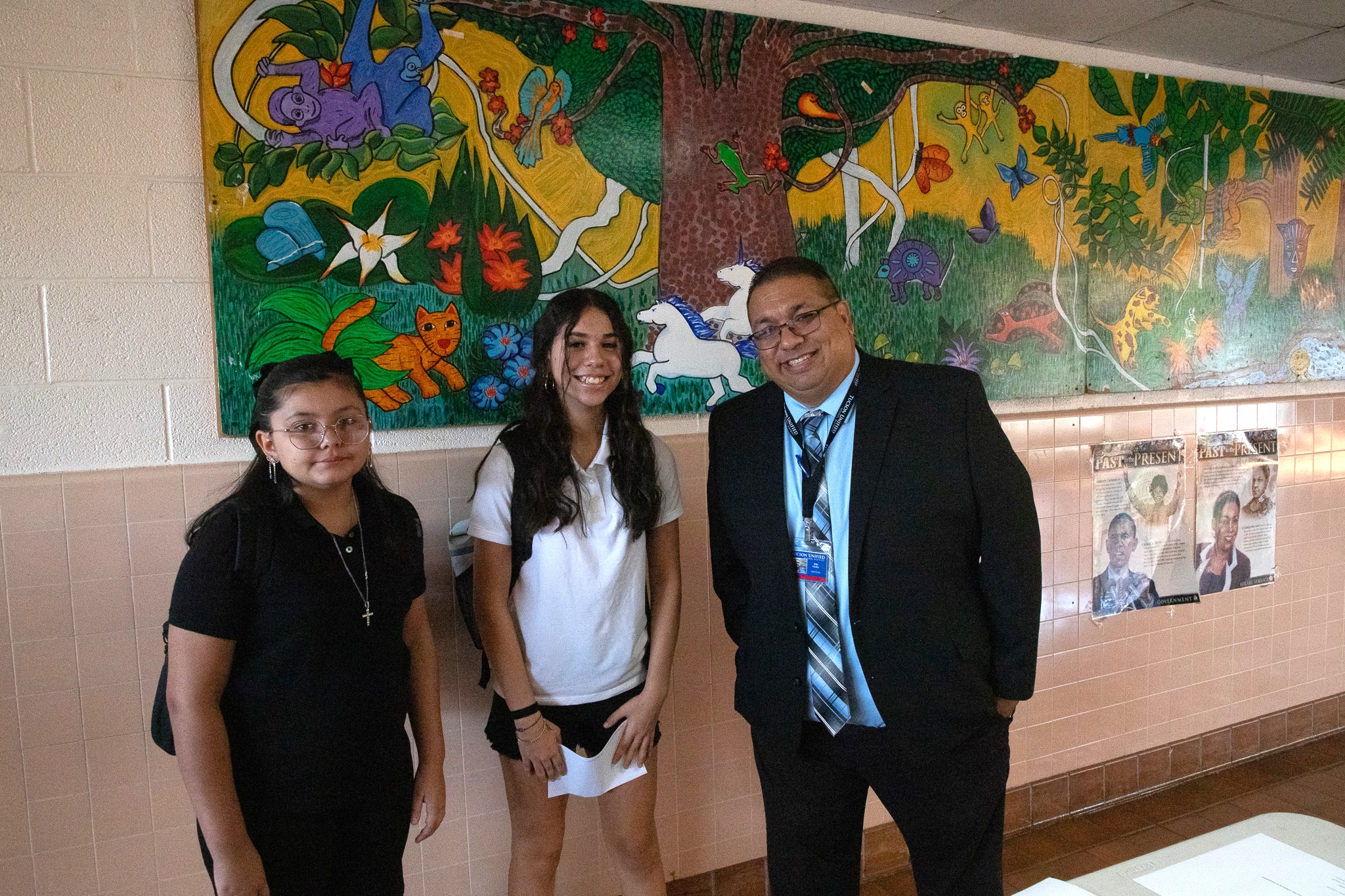 The principal, right, poses with two female students